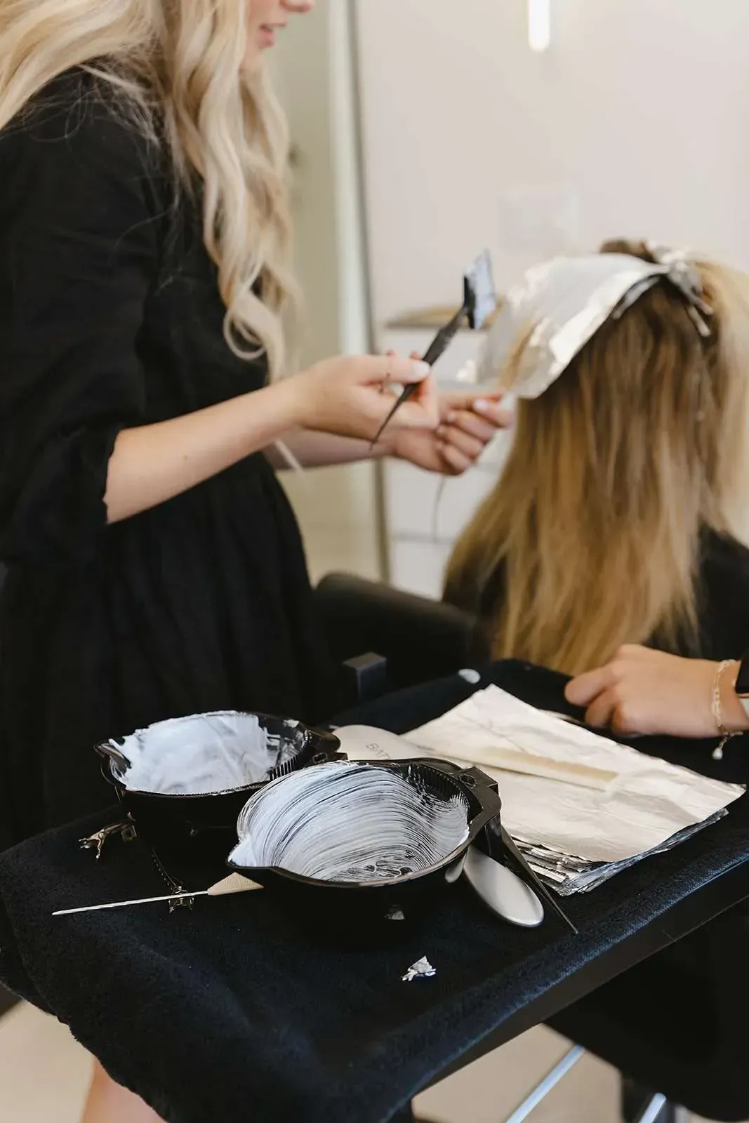A woman is getting her hair dyed in a salon.
