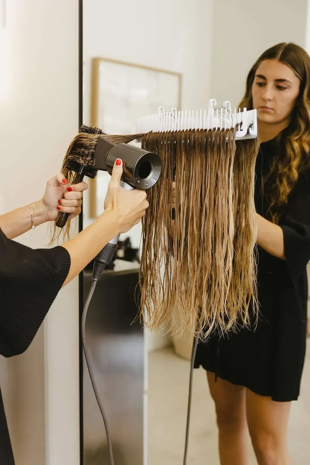 A woman is getting her hair blow dried