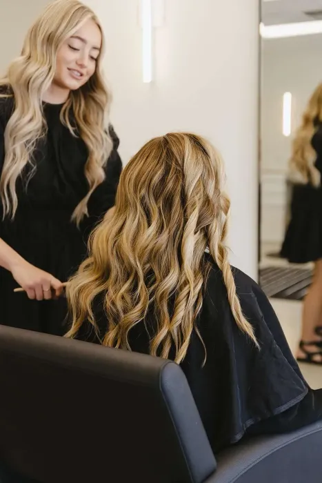 A woman getting her hair done by a hairstylist
