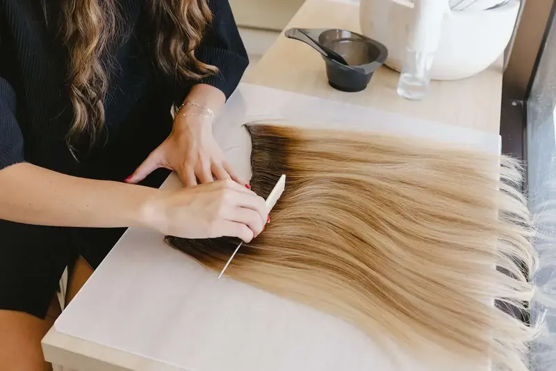 Extension wefts laid out on a table and blended to a guest's color